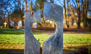 Grabstein in Herzform auf einem Friedhof, symbolisch für Erdbestattungen
